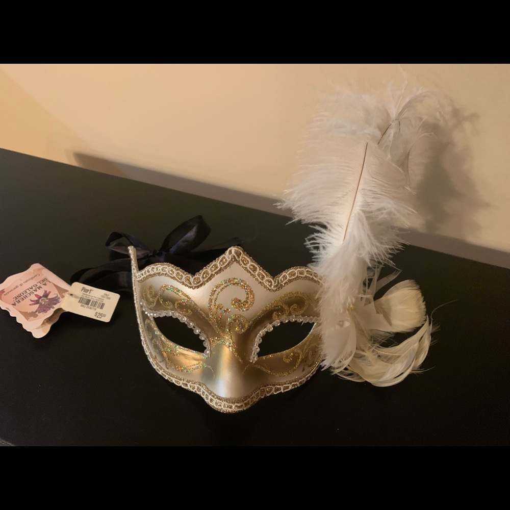 Stunning gold and ivory masquerade mask with feather accent.